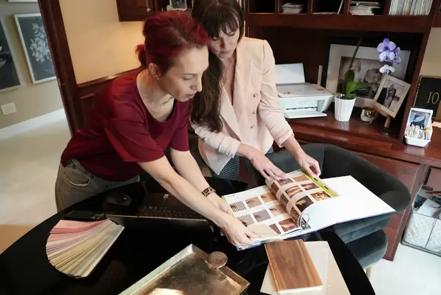 ARIID designers comparing finish samples and a catalog at a studio desk